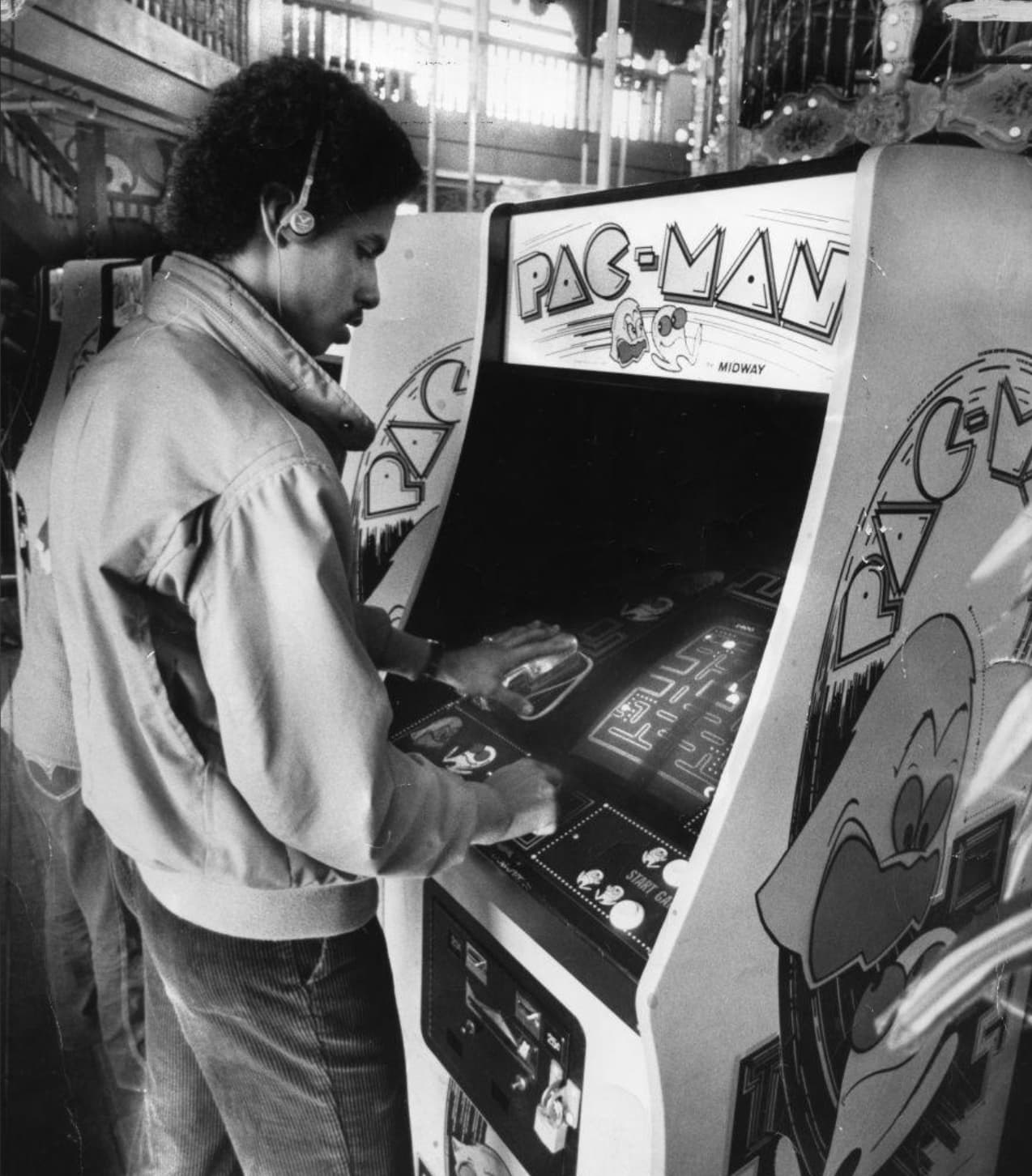 “Man playing Pac-Man at arcade (1980s).” 